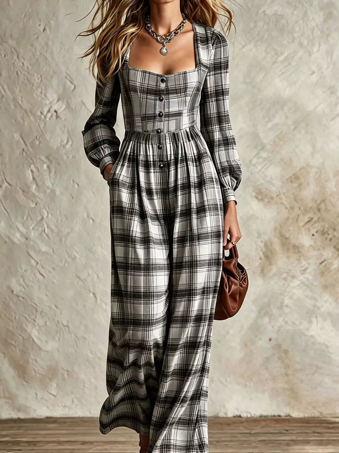 black and white plaid long sleeve jumpsuit with button bodice, styled with a brown bag