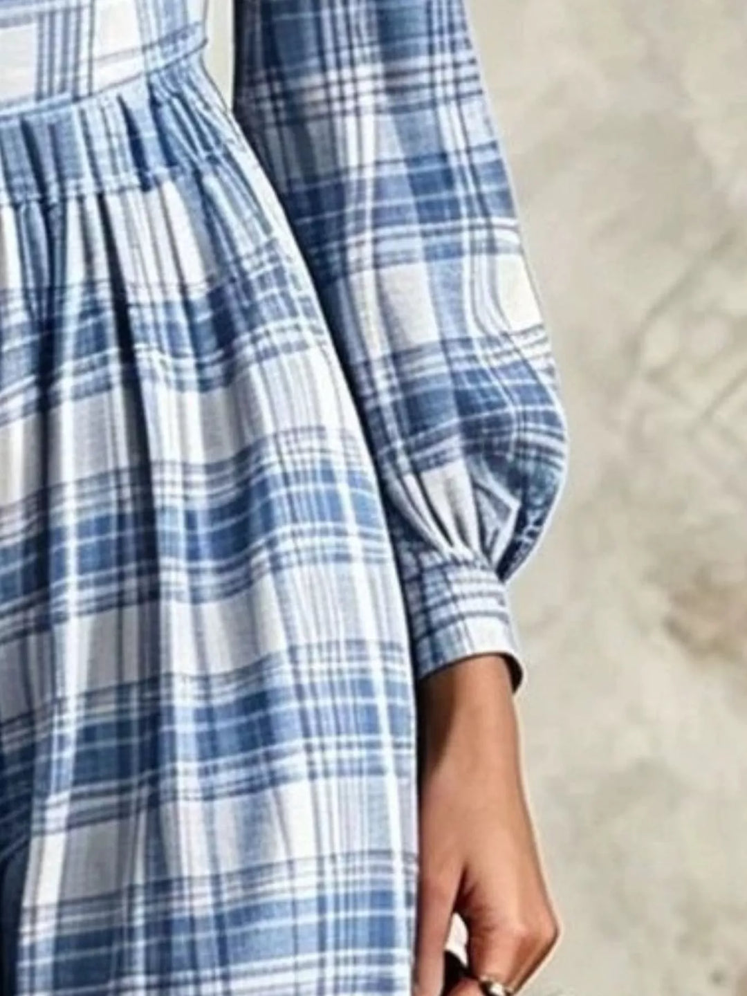 Close-up of light blue plaid jumpsuit cuff and flowing wide leg