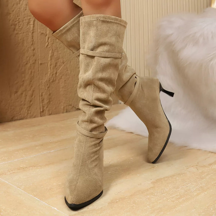 Beige slouchy kitten heel boots with pointed toe, worn standing
