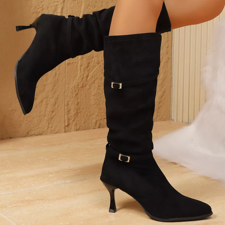 Side view of black pointed toe boots with kitten heel and buckles