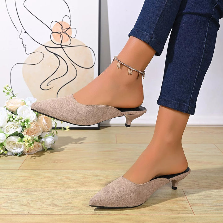 Taupe pointed toe backless mules with kitten heel, worn with jeans