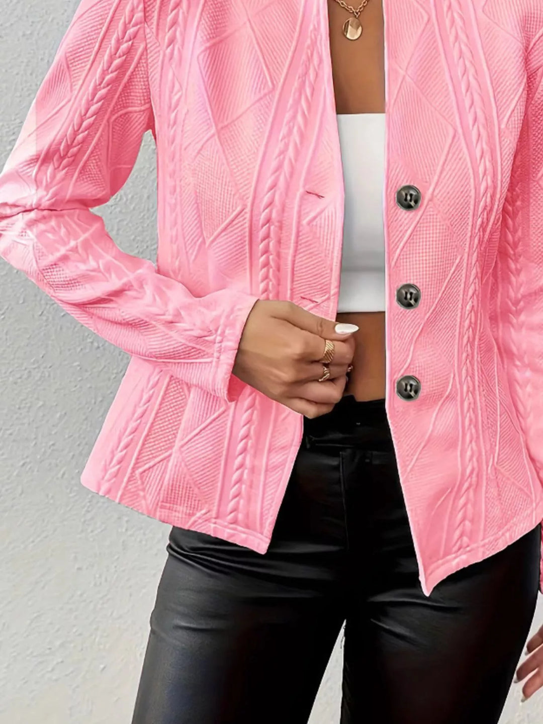Detail of the pink knit blazer button front worn over a white top