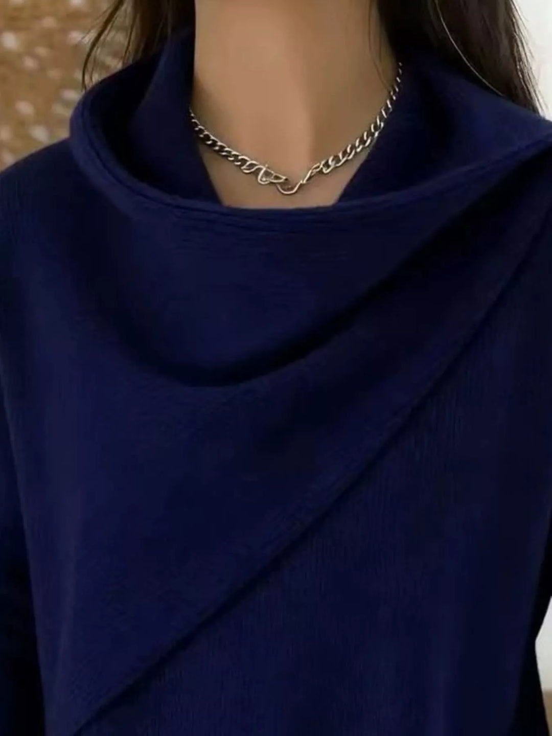 Draped diagonal cowl neck ribbed hem in navy, close-up detail
