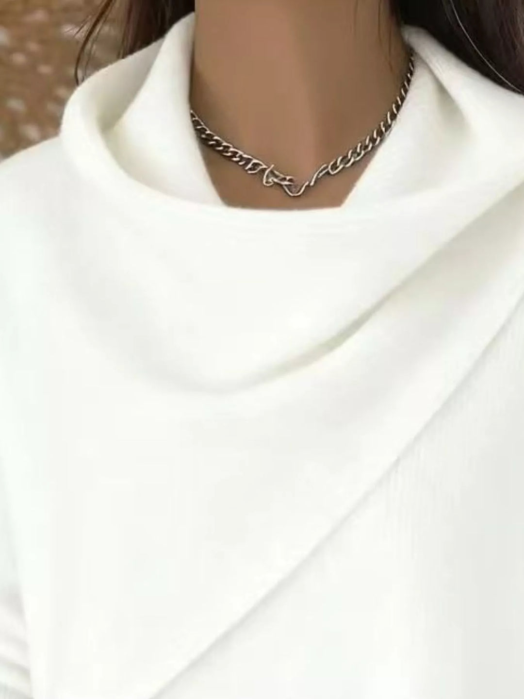 Draped diagonal cowl neck ribbed hem in white, close-up detail
