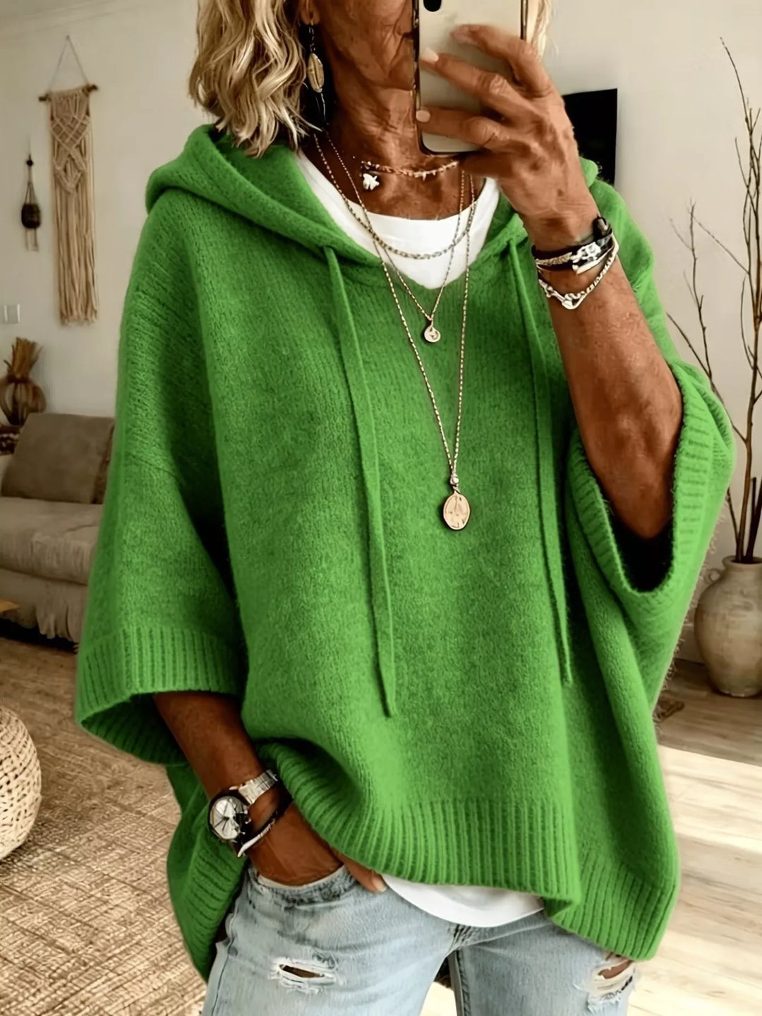 Green hooded knit sweater with drawstrings and relaxed batwing sleeves
