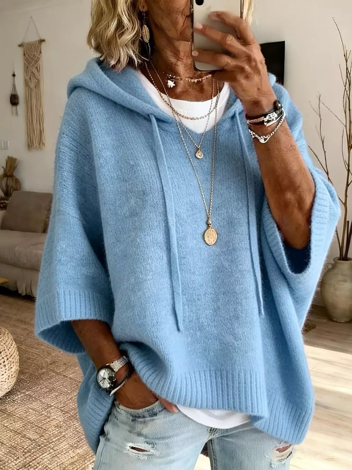 Light blue hooded batwing sleeve sweater with drawstrings over a white tee
