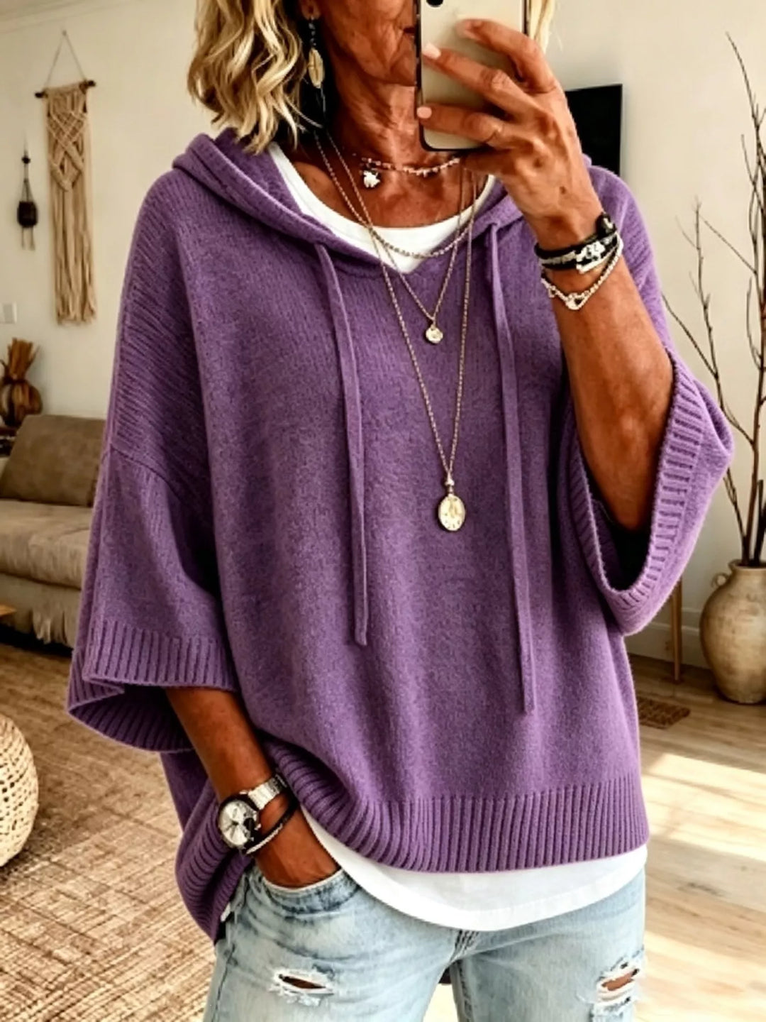 Purple batwing sleeve hooded sweater with a hand resting in the jeans pocket