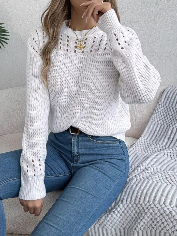 White knit sweater with openwork yoke, seated pose with hand at chin
