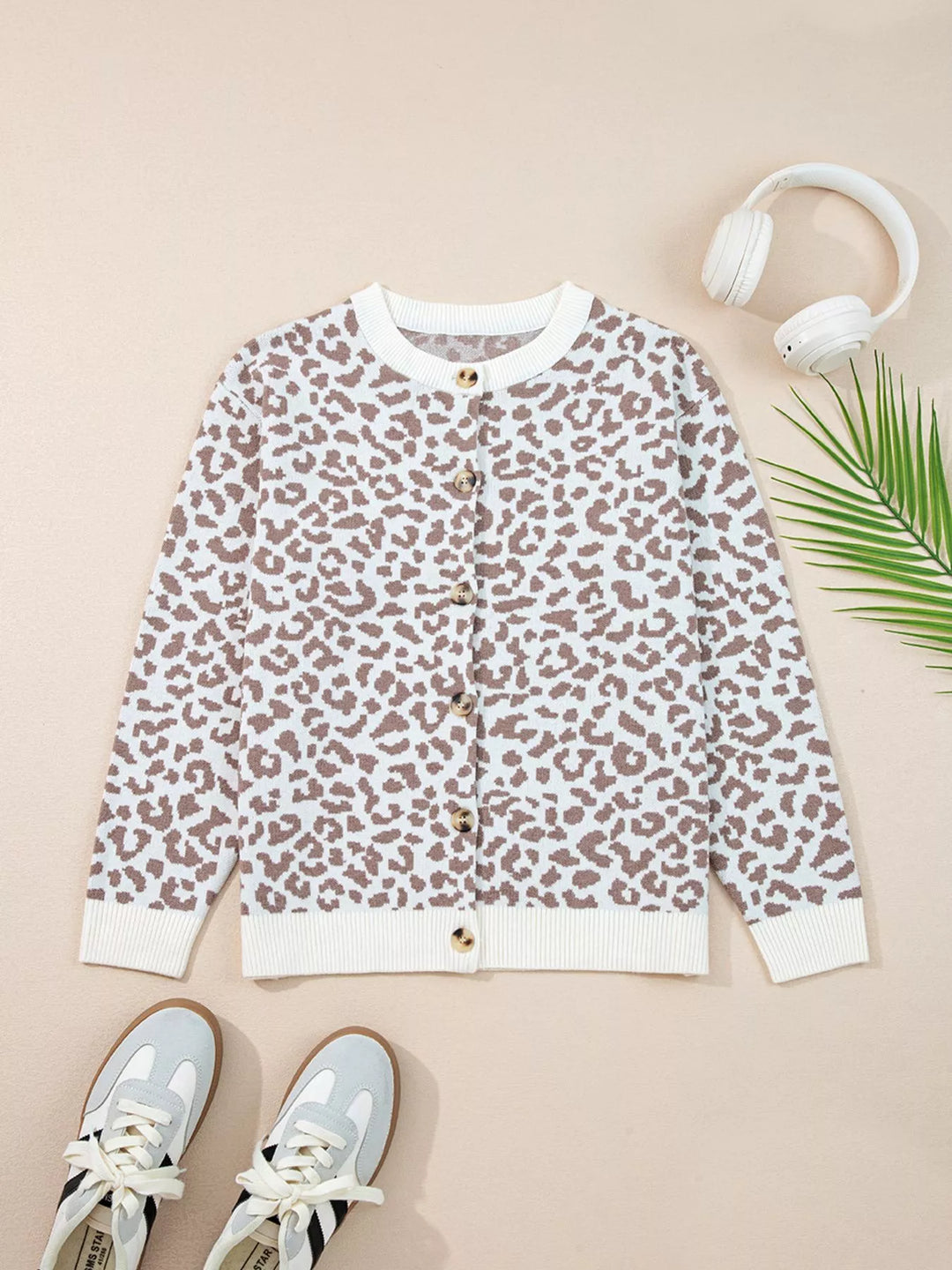 Ivory leopard cardigan laid flat with sneakers and headphones, front view