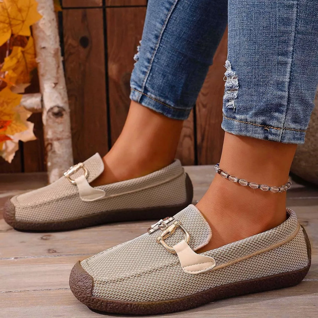 Beige buckle flats side view with a woven upper and brown sole