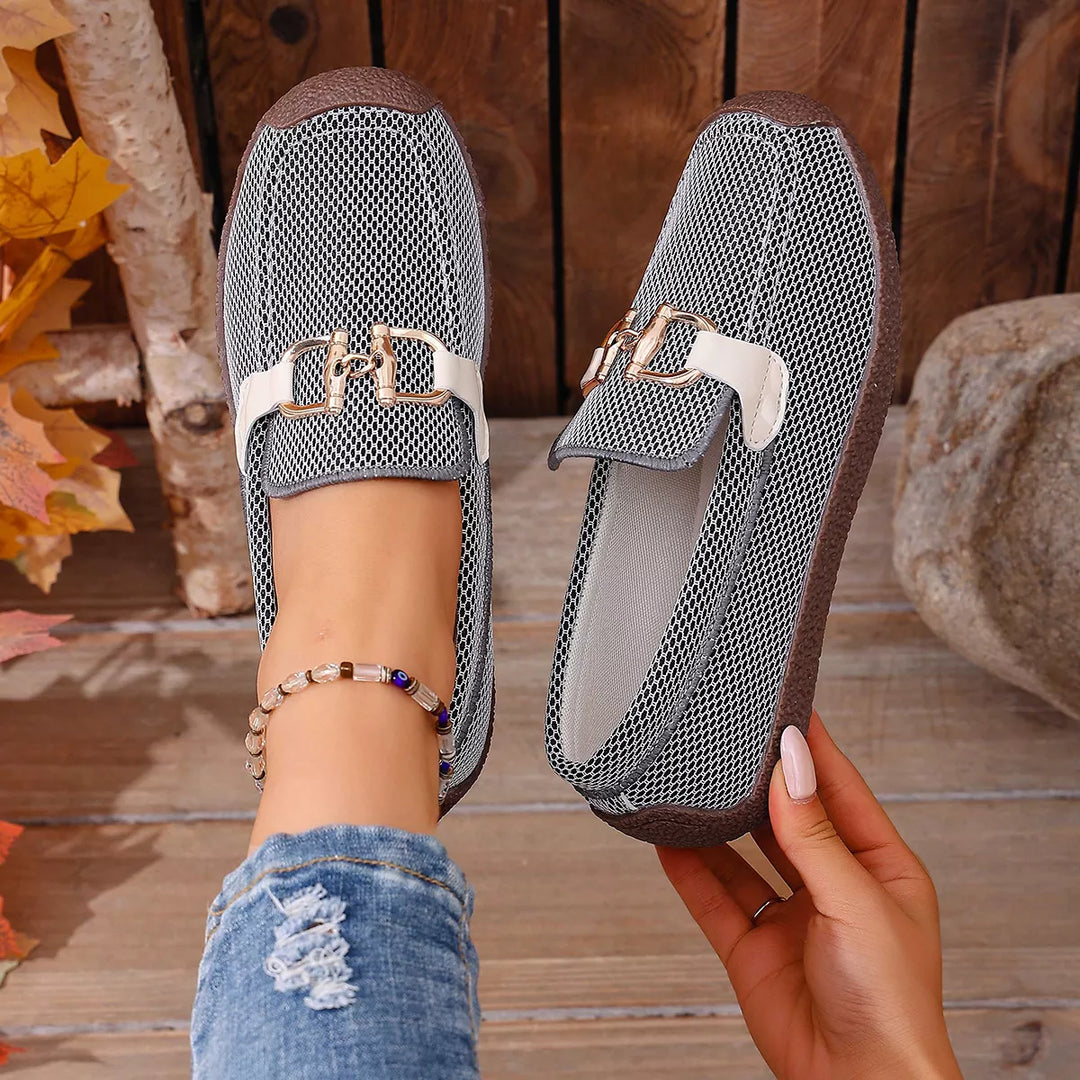 Pair of gray slip on buckle loafers held up showing the top and side