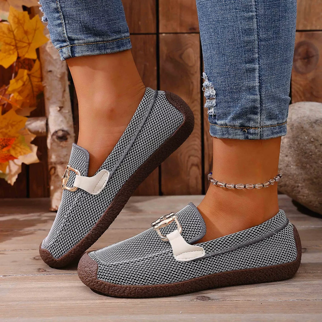 Side view of the gray slip on loafer with a gold and cream buckle