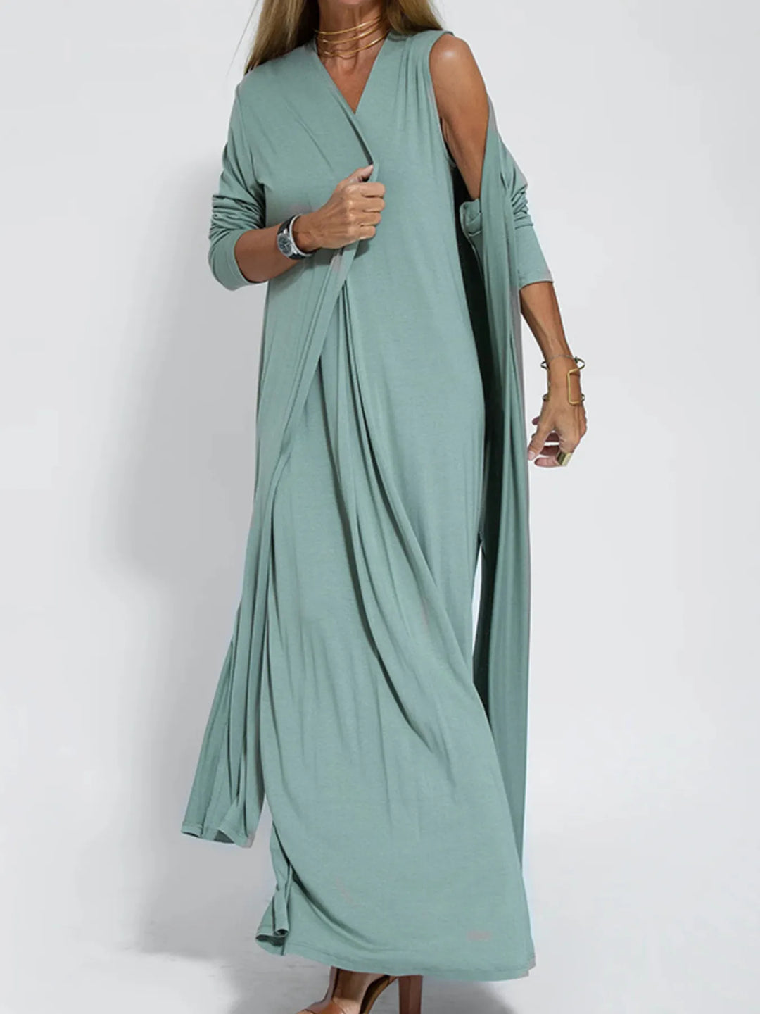 Sage green duster cardigan worn open, standing with a hand at the sleeve