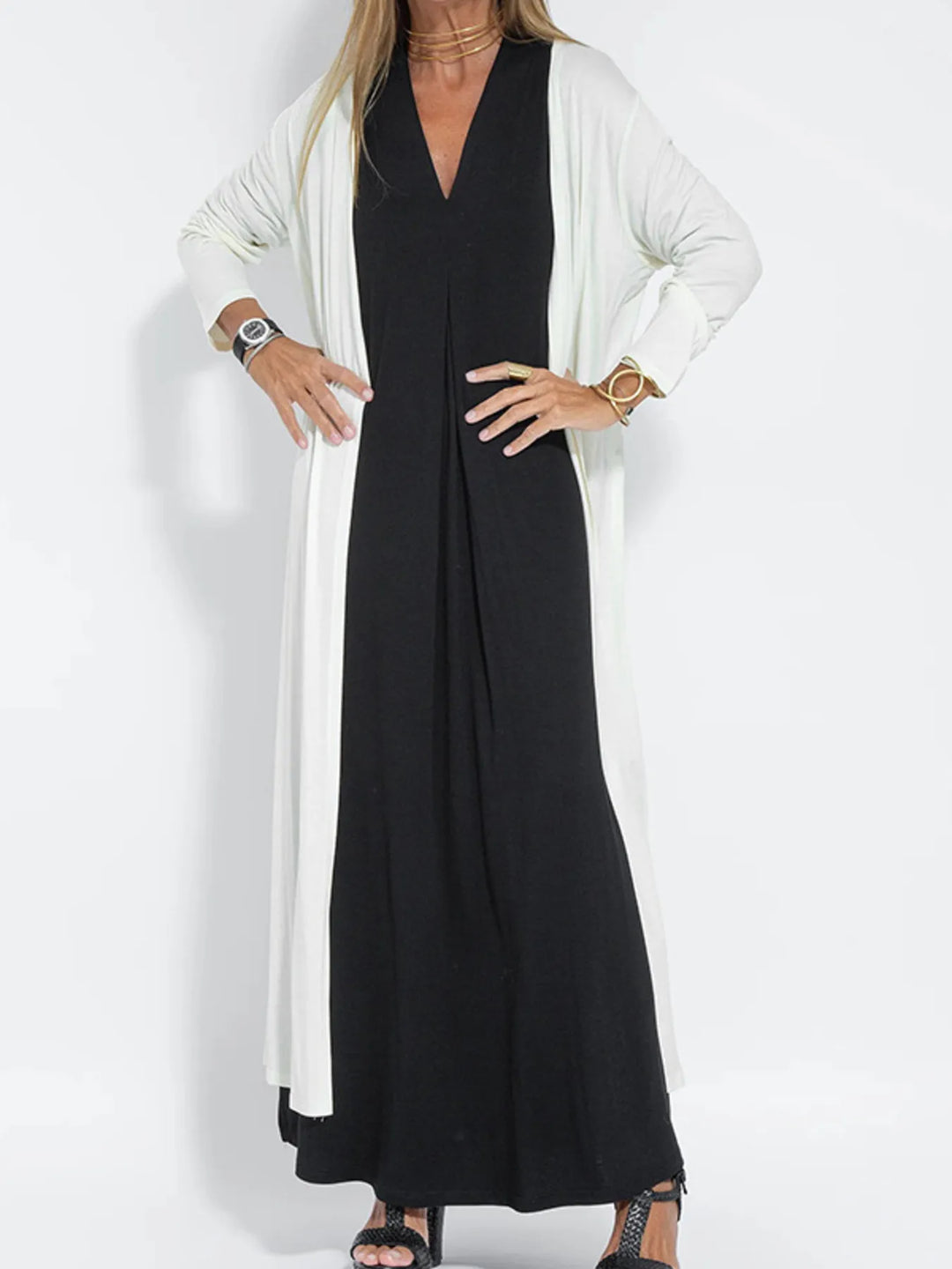 White long cardigan worn open over a black maxi dress