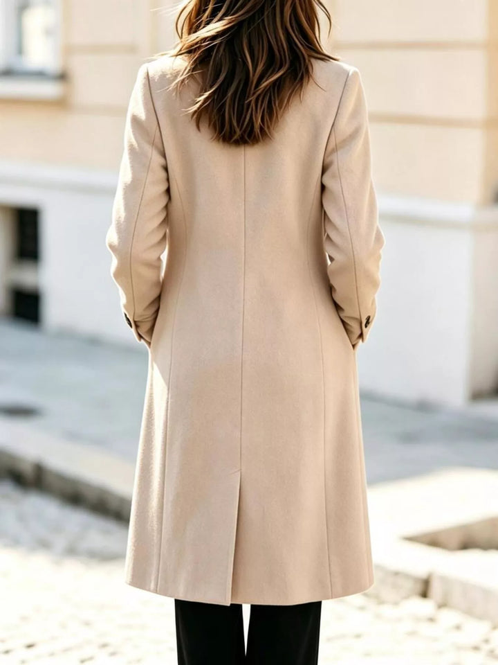 Back view of the cream mid calf long coat with a rear vent