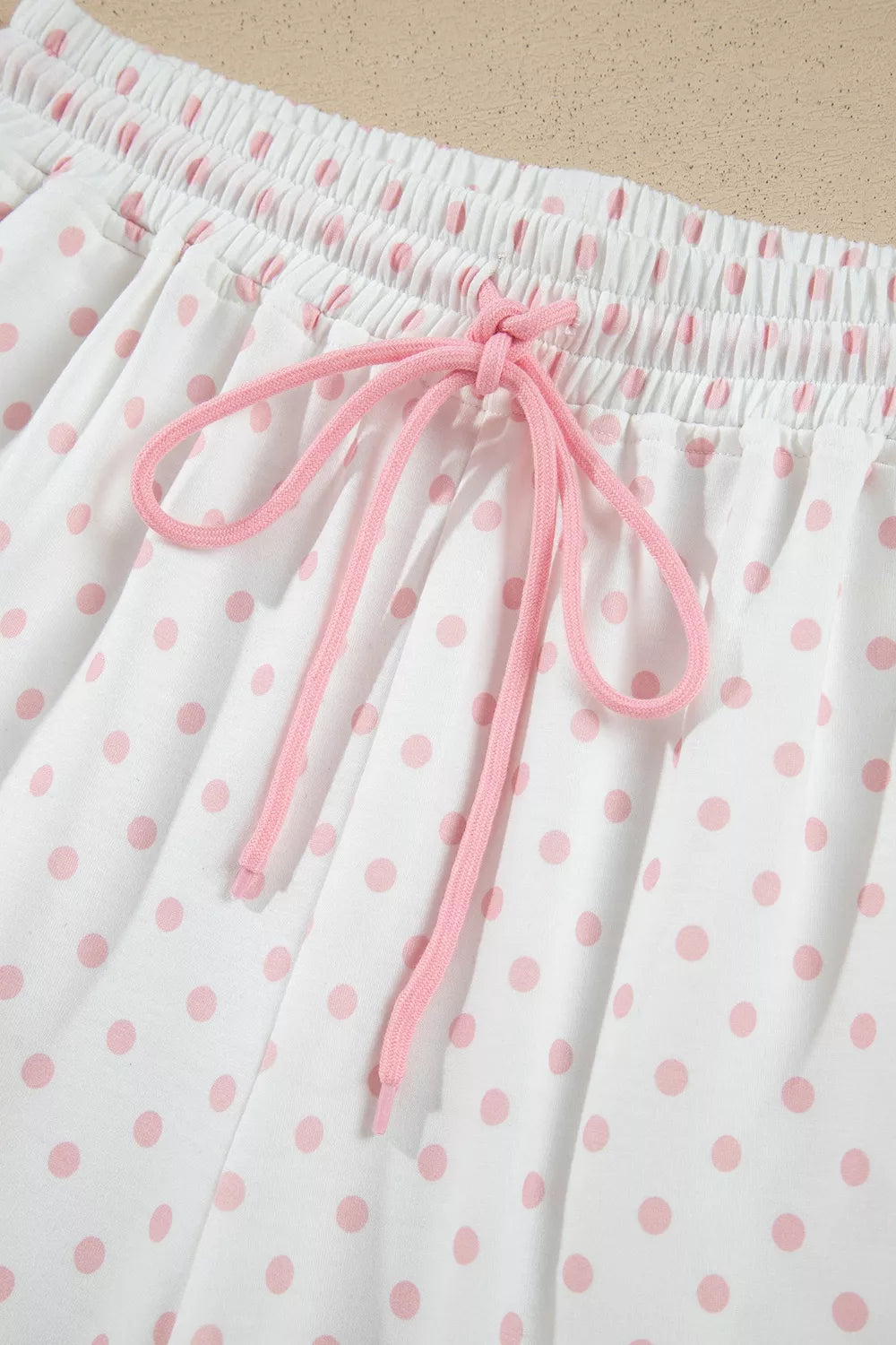 Close-up of the pink drawstring tied on the polka dot lounge pants