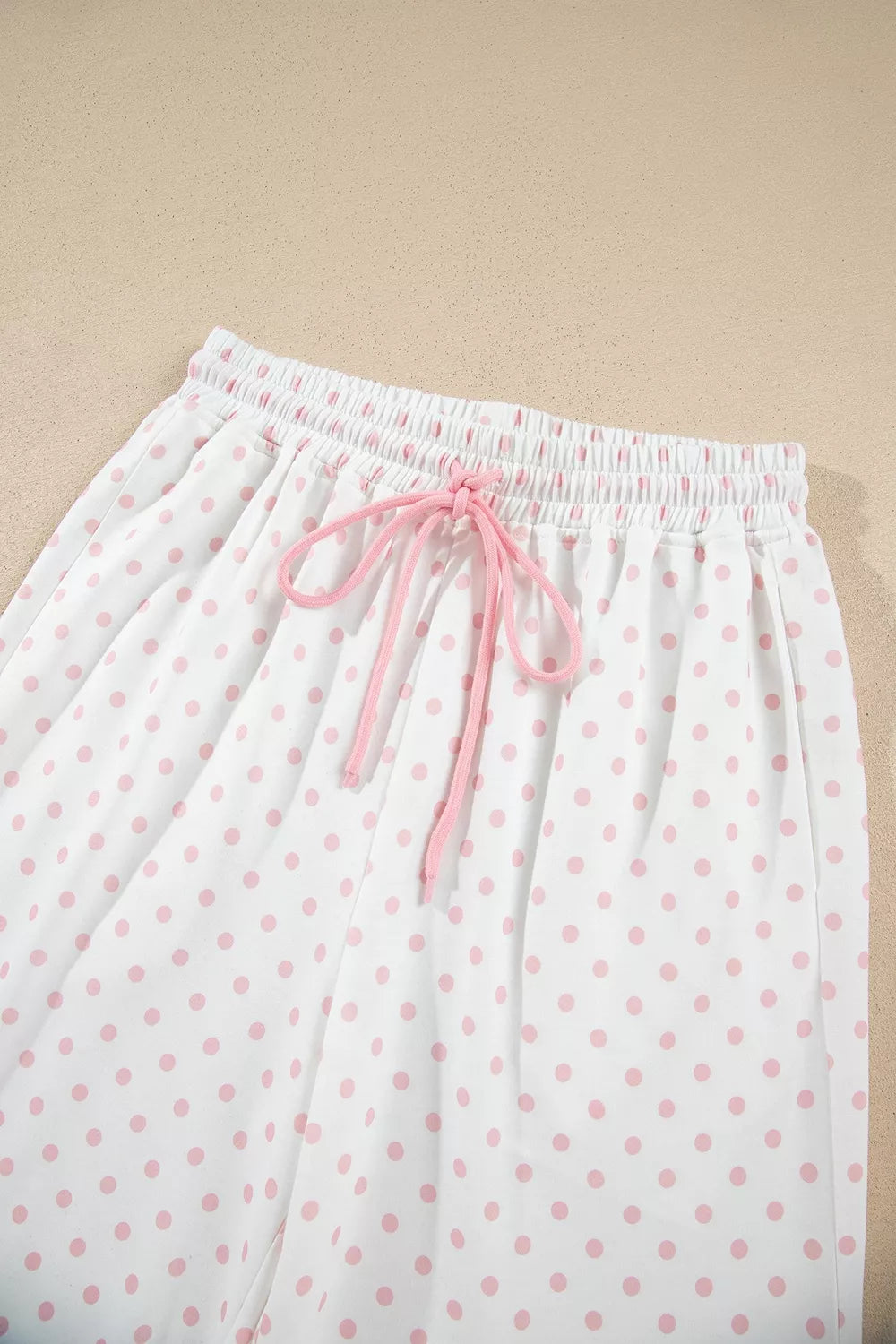 Detail of the polka dot pants waistband with pink drawstring bow