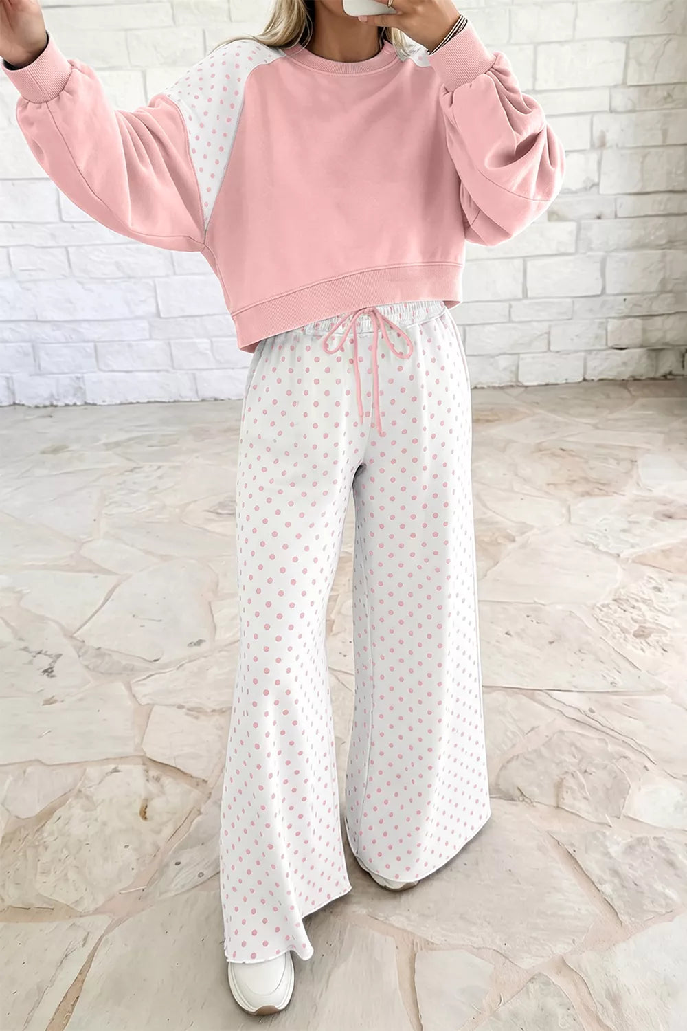 Blush lounge set with one arm raised, showing the cropped sweatshirt and drawstring pants