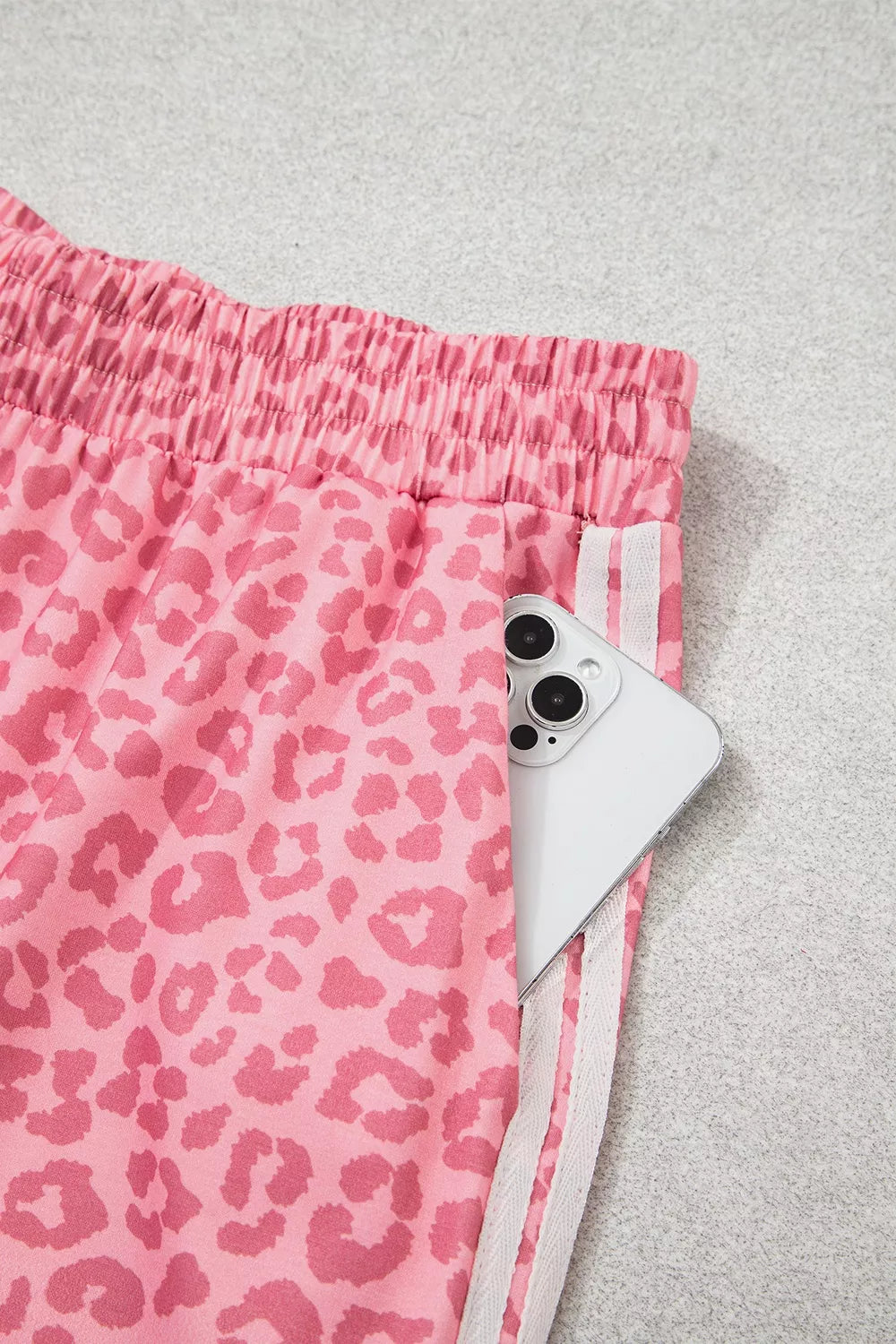 Detail of pink leopard wide leg pants with side pocket and white stripe