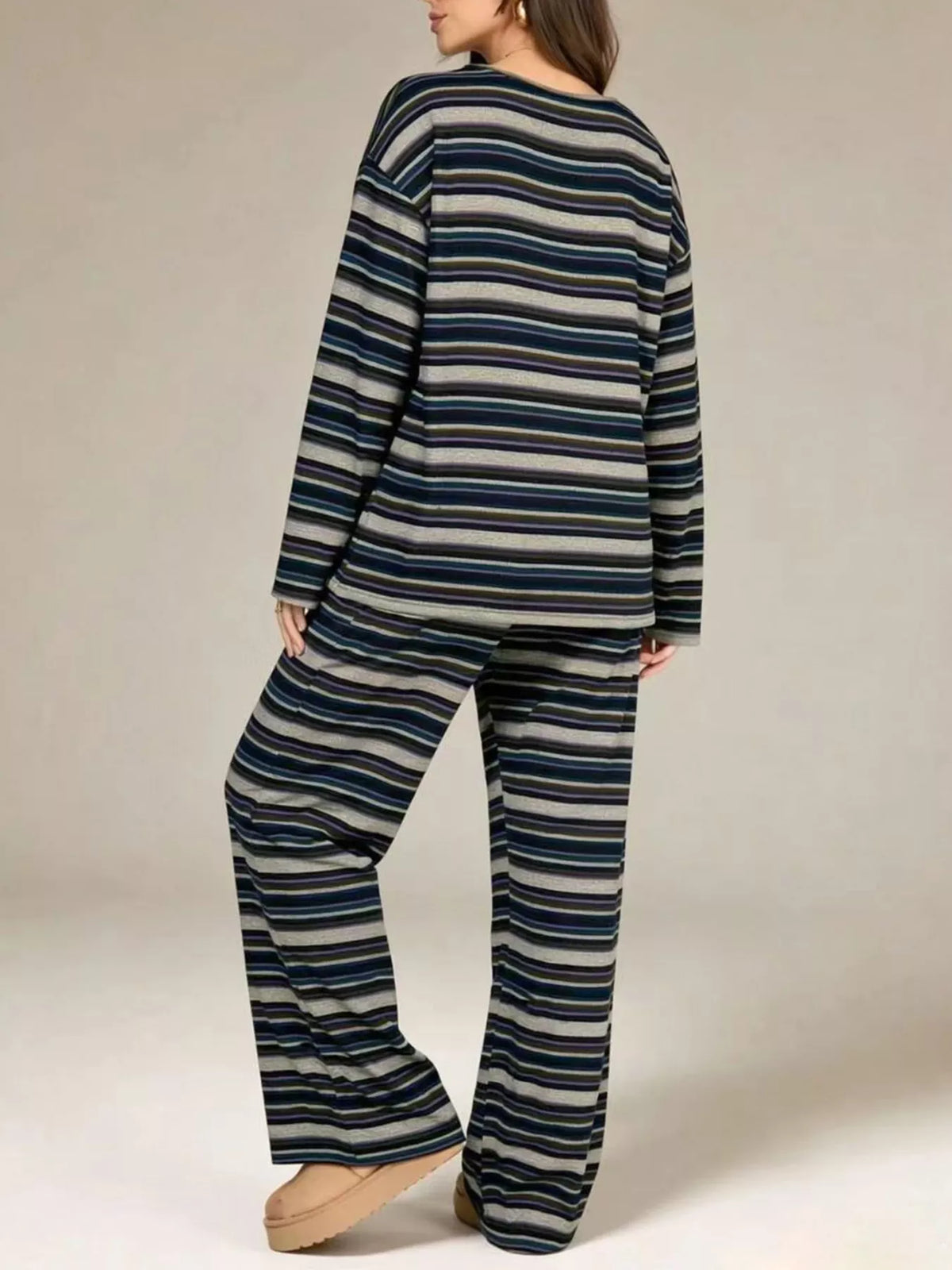 Blue stripe top and pants outfit in a side turn, hand at hip