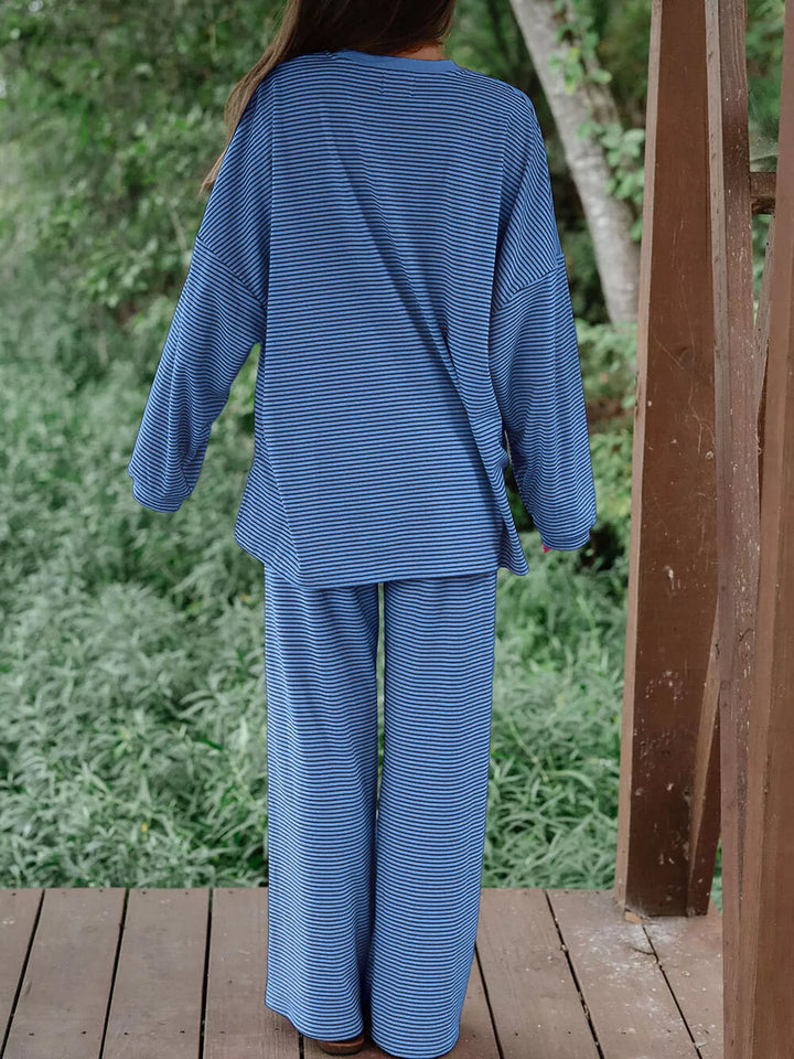 Blue lounge set seen from behind, with greenery in the background