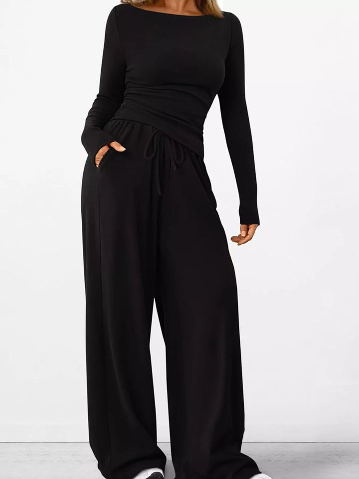 Women's lounge set in black, ribbed knit ruched top and wide leg pants, hand in pocket