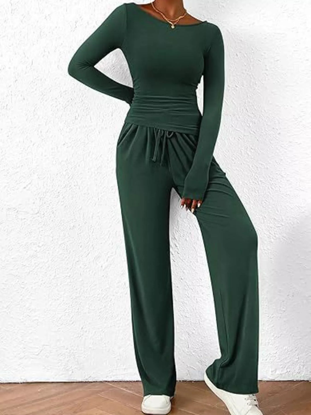 Forest green lounge set with hand on hip and white sneakers