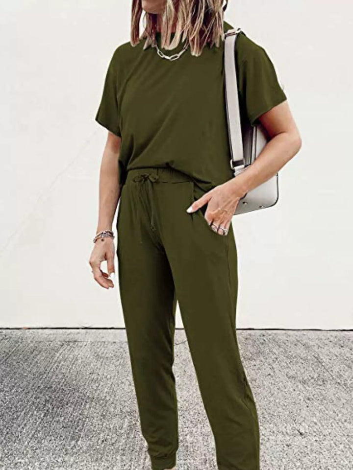 Army green tee and joggers with a white bag over the shoulder