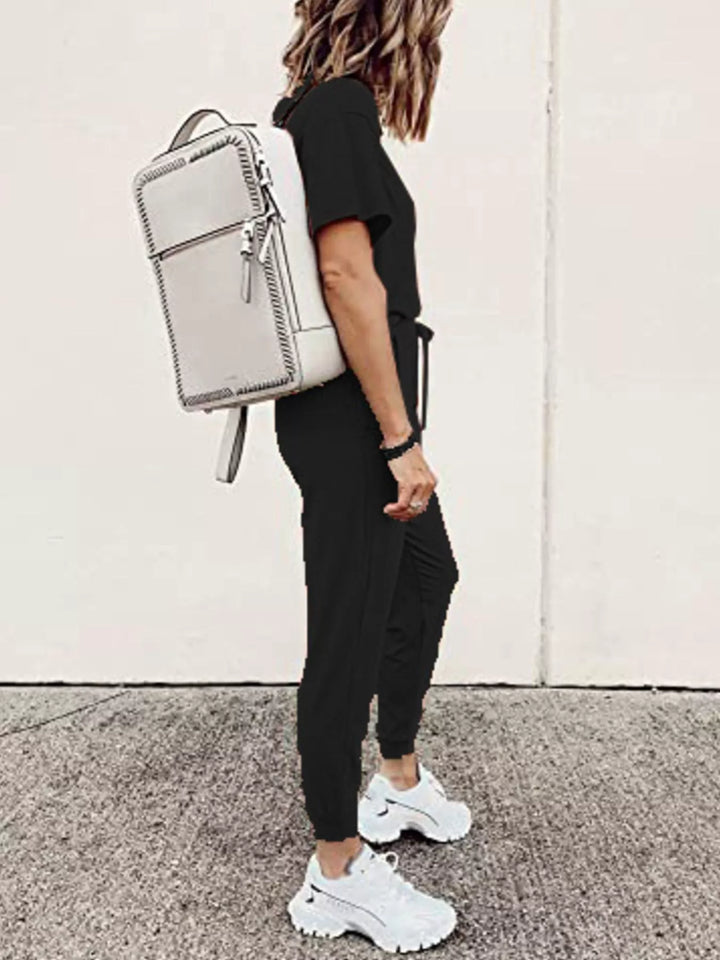 Black tee and jogger pants outfit from the side with a white backpack