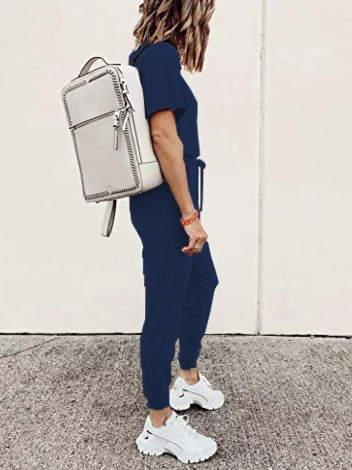 Navy tee and joggers outfit side view, white backpack and chunky sneakers