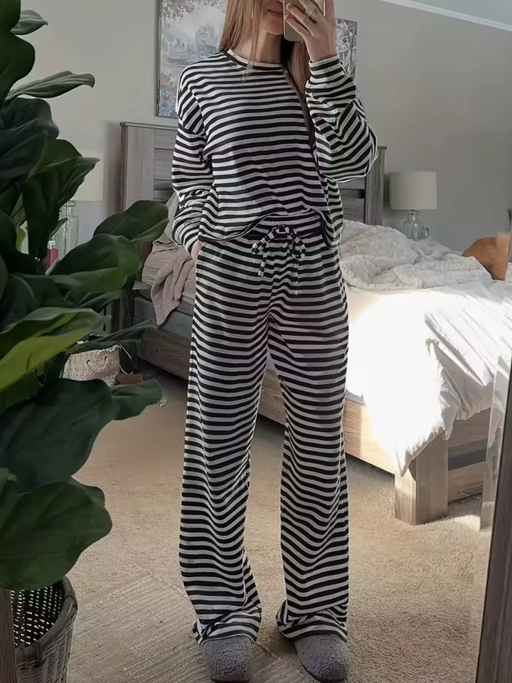 Black striped long sleeve top and wide leg pants, full length on a wood floor