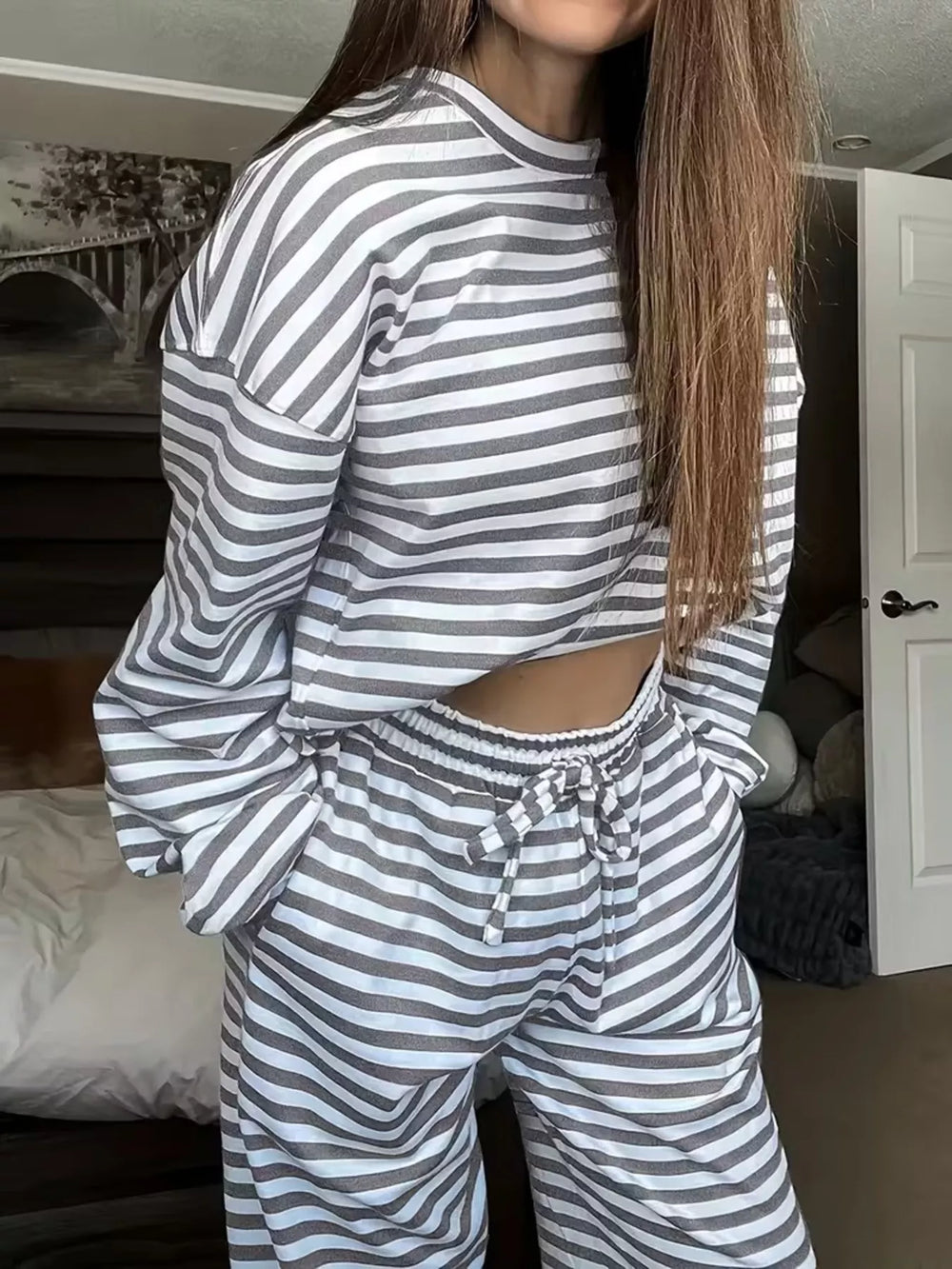 Gray striped lounge set worn with hand in pocket, cropped top and wide pants