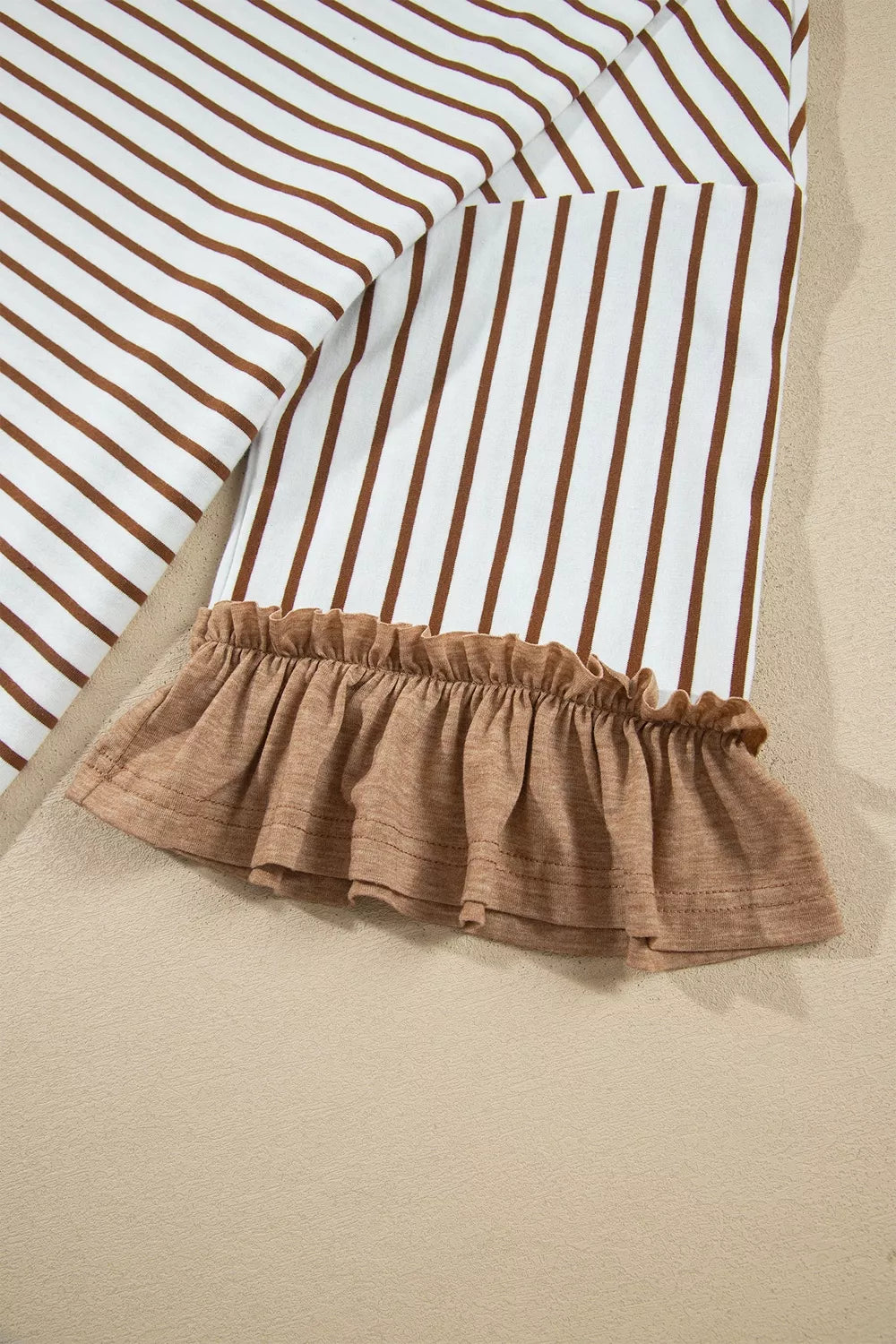 Close-up of the striped sleeve with ruffled cuff in camel