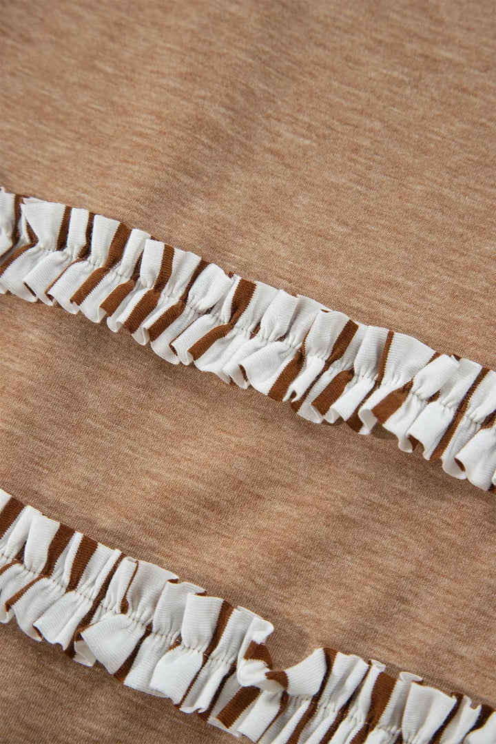 Close-up of the striped ruffle trim on the camel pants leg
