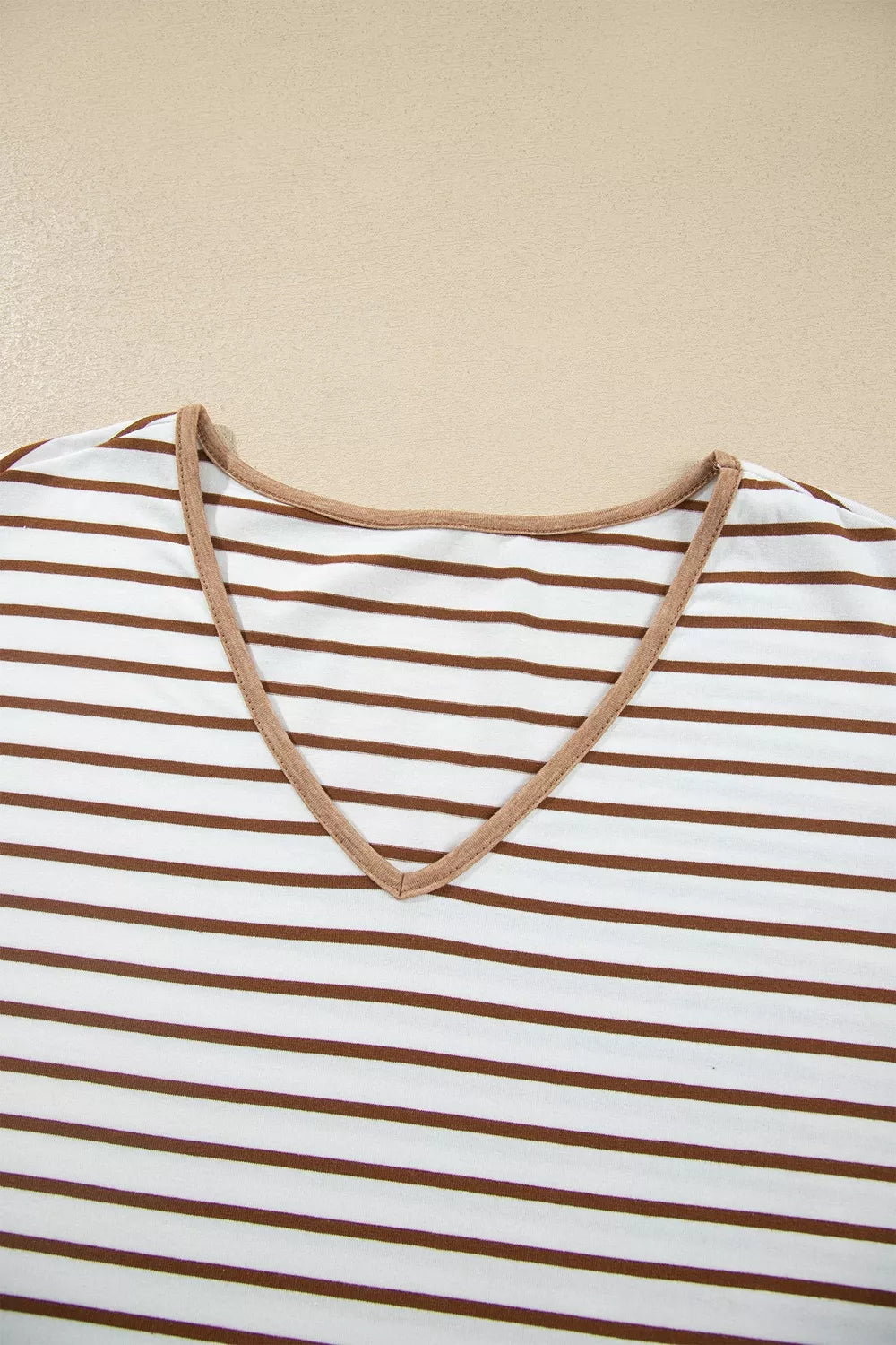 Close-up of the striped V neckline with camel trim
