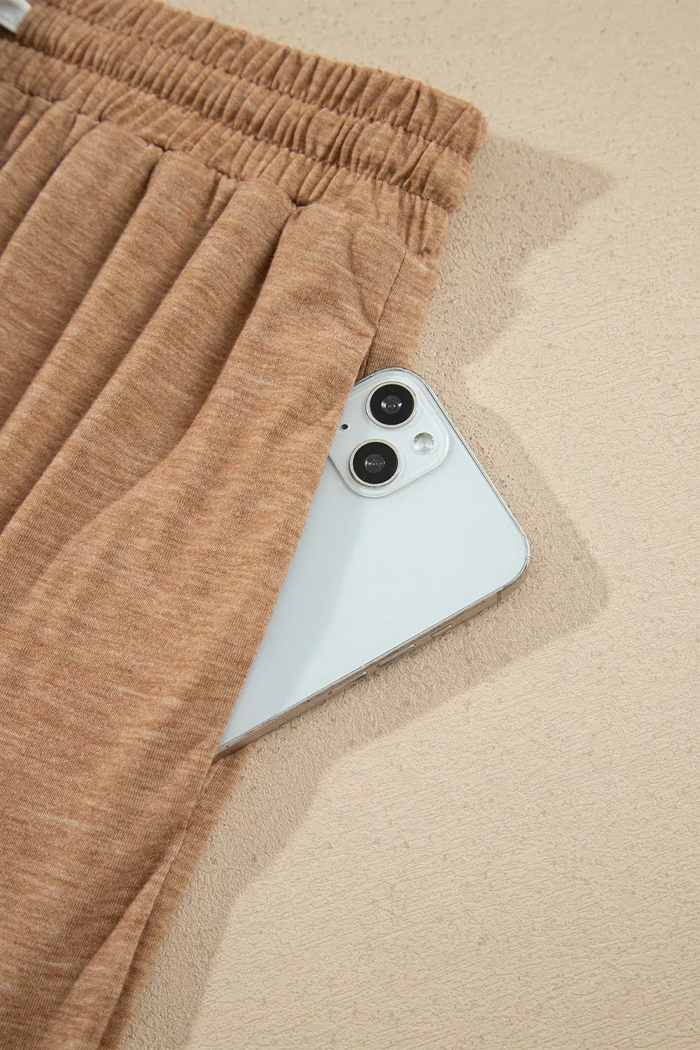 Side pocket of the camel lounge pants holding a phone