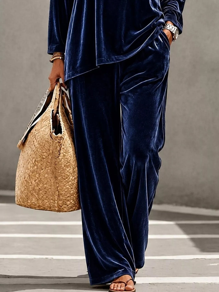 Navy velvet wide leg pants with a straw tote, cropped view