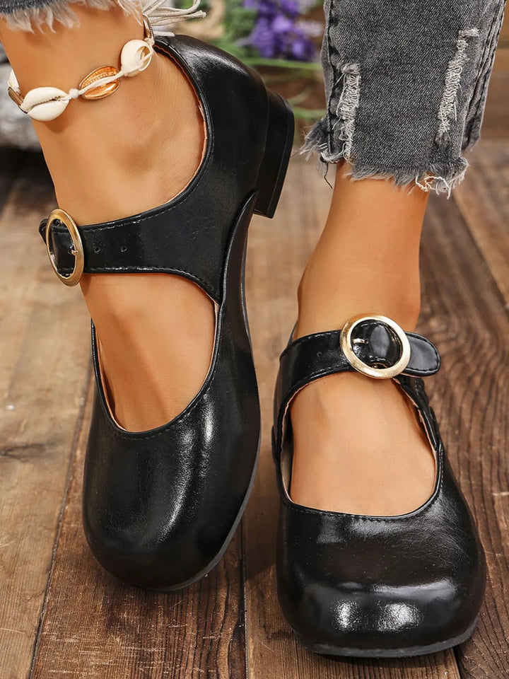Black block heel Mary Jane shoes with cutout strap, worn with cuffed jeans
