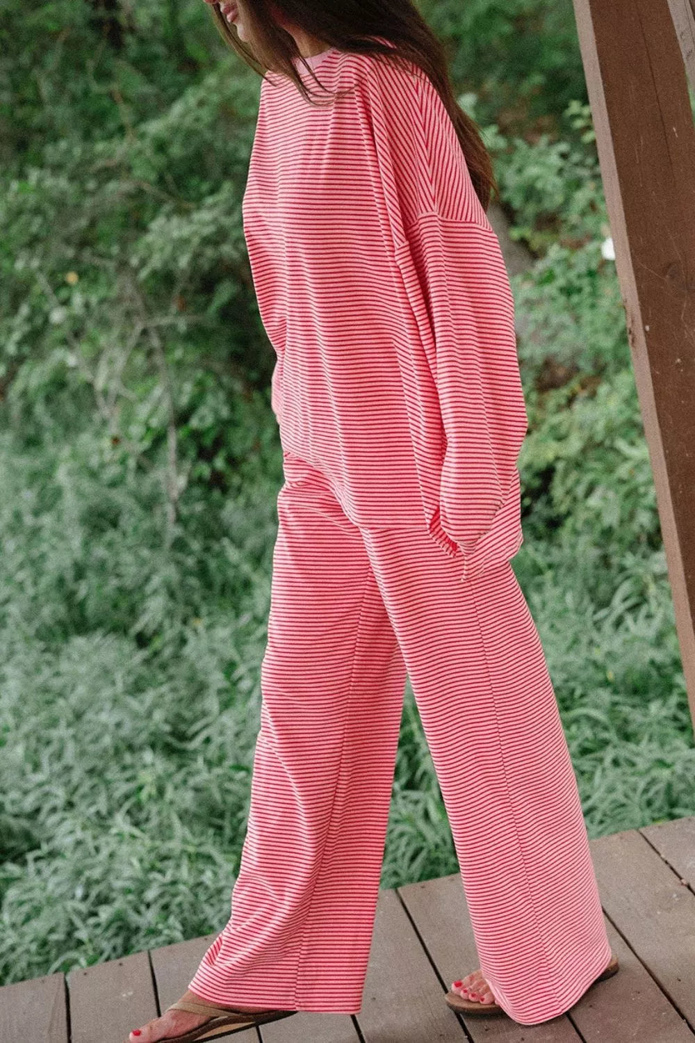 Side view of the dusty pink matching lounge set standing by a wooden post