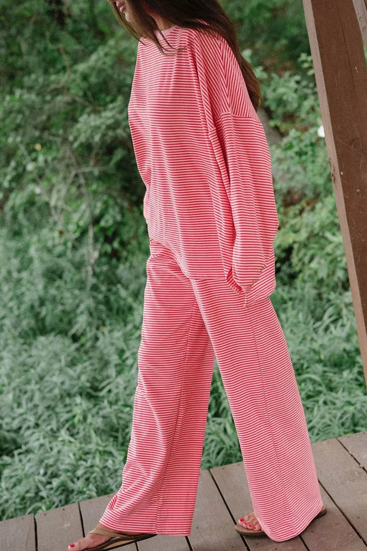 Side view of the dusty pink matching lounge set standing by a wooden post