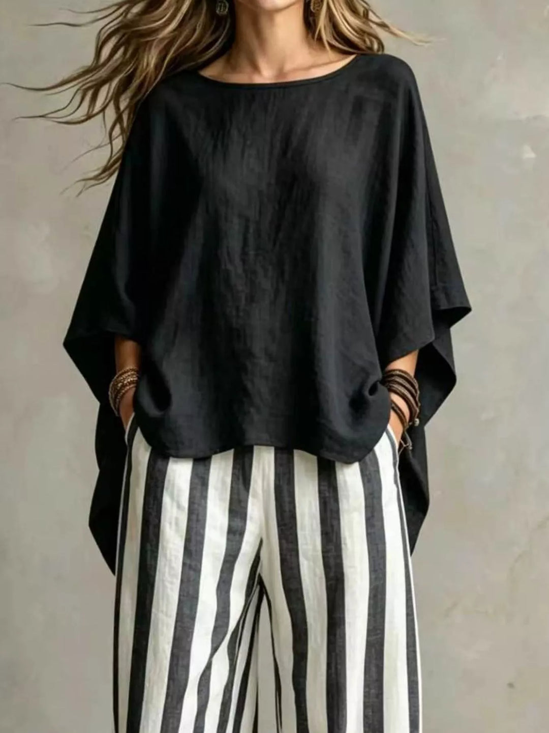 Black batwing sleeve top and striped wide leg pants, closer front view