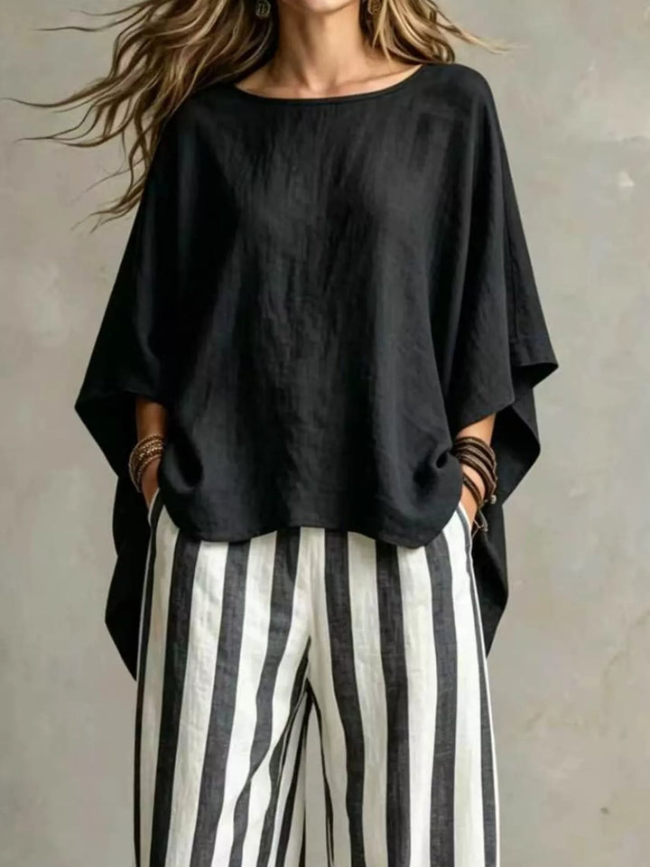 Black batwing sleeve top and striped wide leg pants, closer front view