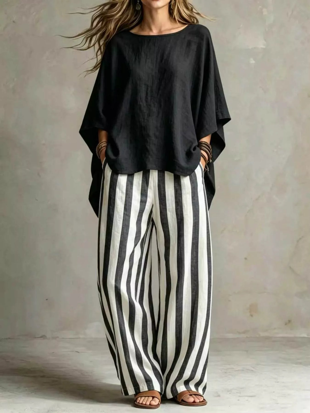 Black batwing top with black and white striped wide leg pants, full length