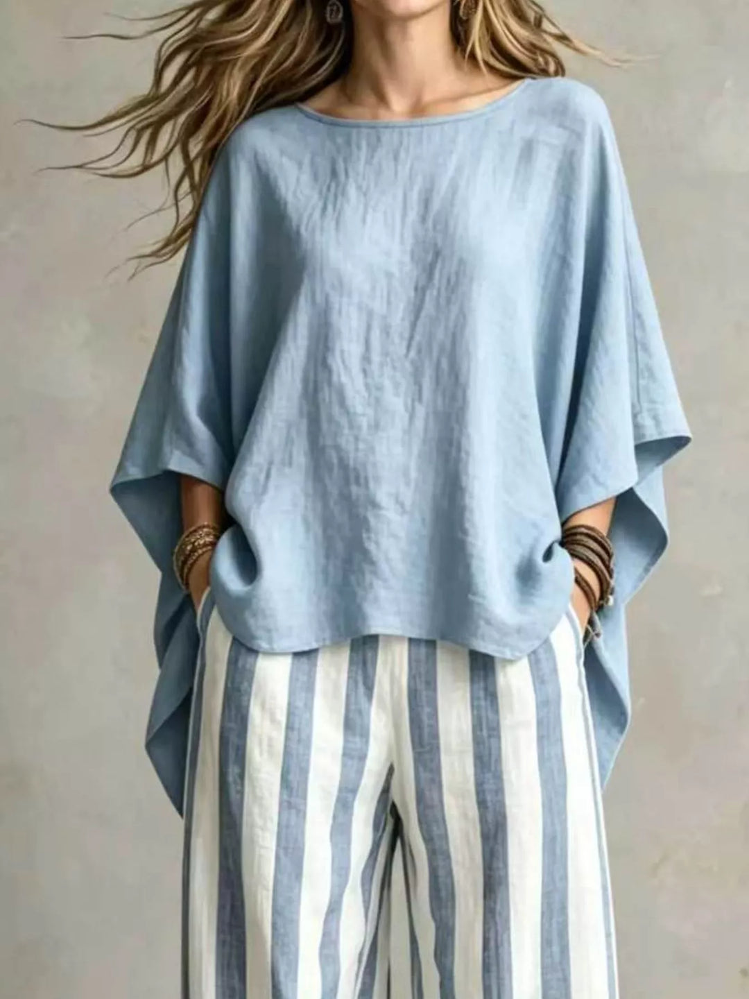 Light blue batwing sleeve top with striped pants, closer front view