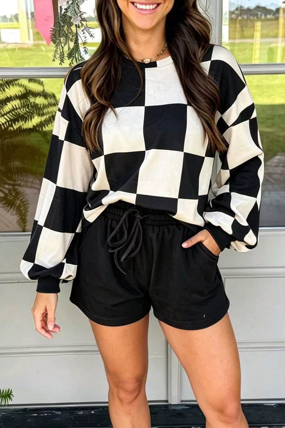 Black and white checkerboard top with drawstring shorts, styled outdoors on model