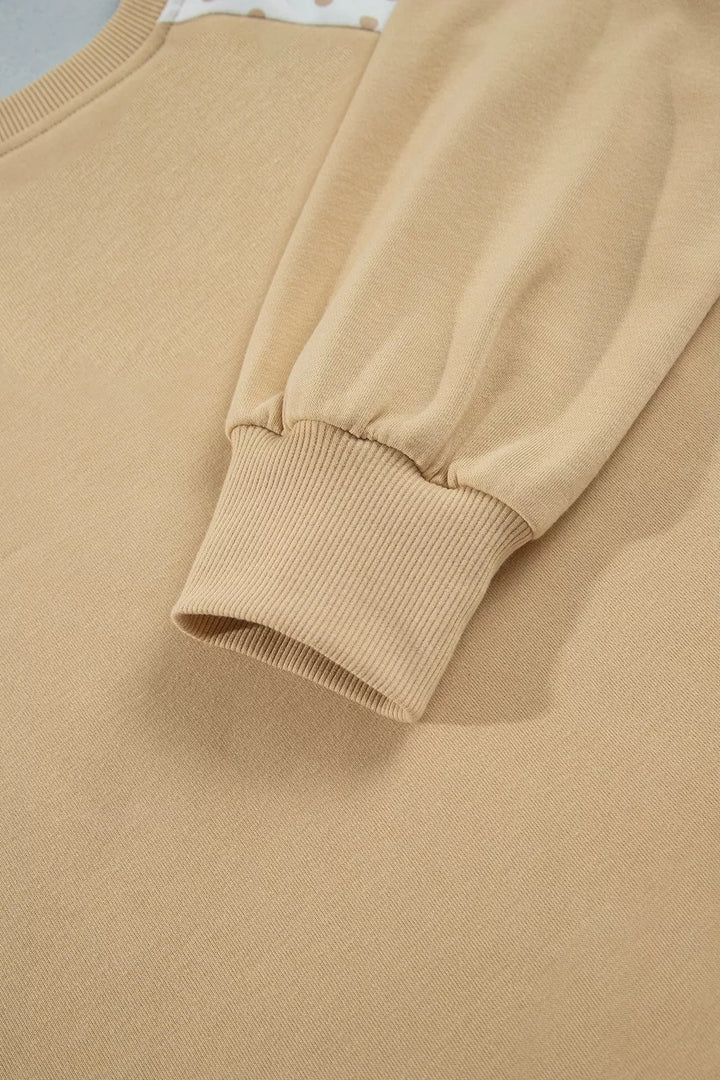 Close-up of the tan sweatshirt sleeve with ribbed cuff