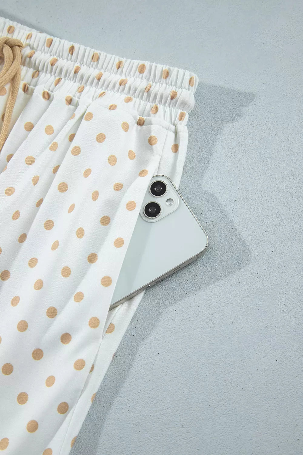 Side pocket of the polka dot wide leg pants holding a phone