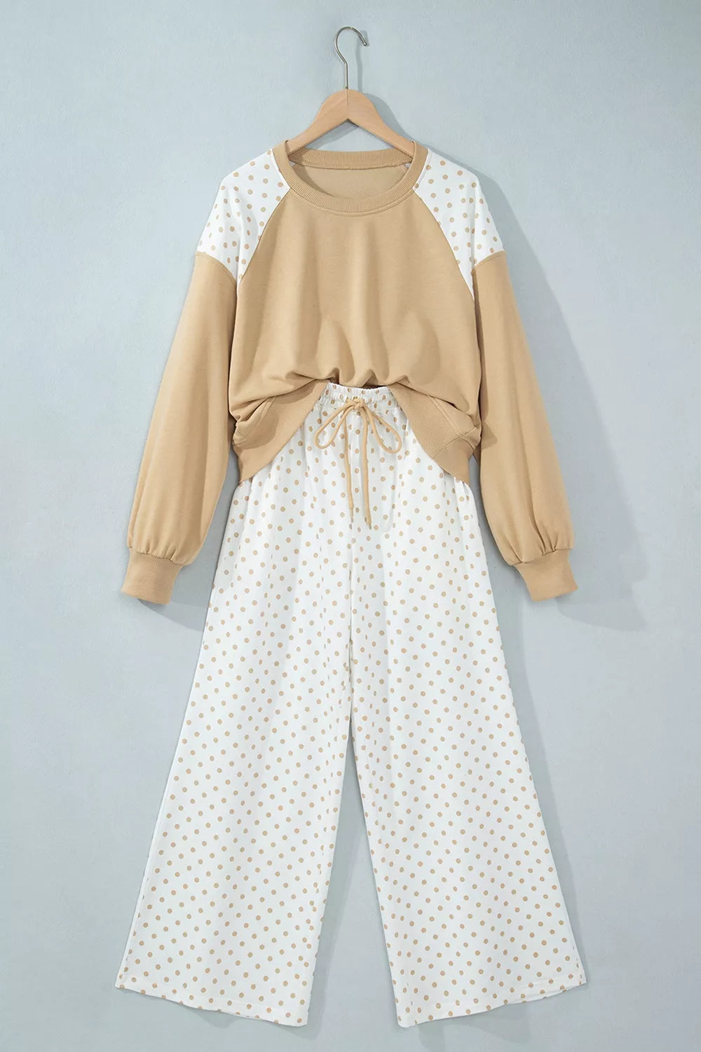 Tan cropped sweatshirt and wide leg pants hanging together, front view