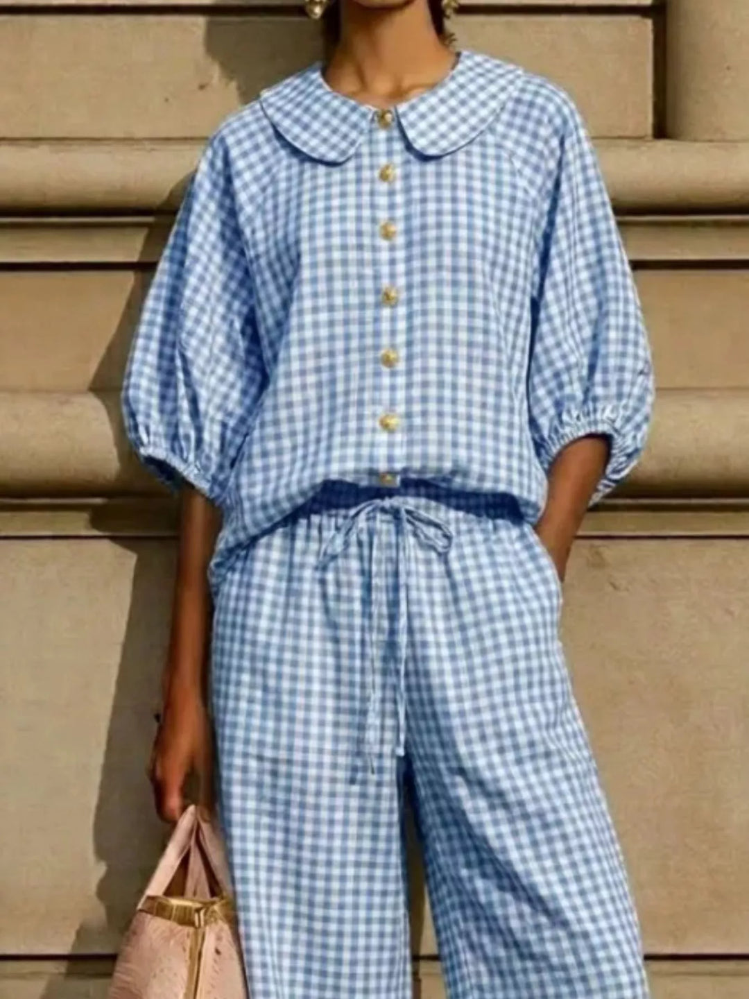 Close-up of light blue gingham top with Peter Pan collar, button front and puff sleeves