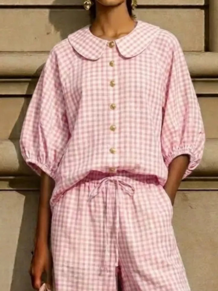 Close-up of pink gingham button front top with puff sleeves and drawstring waist
